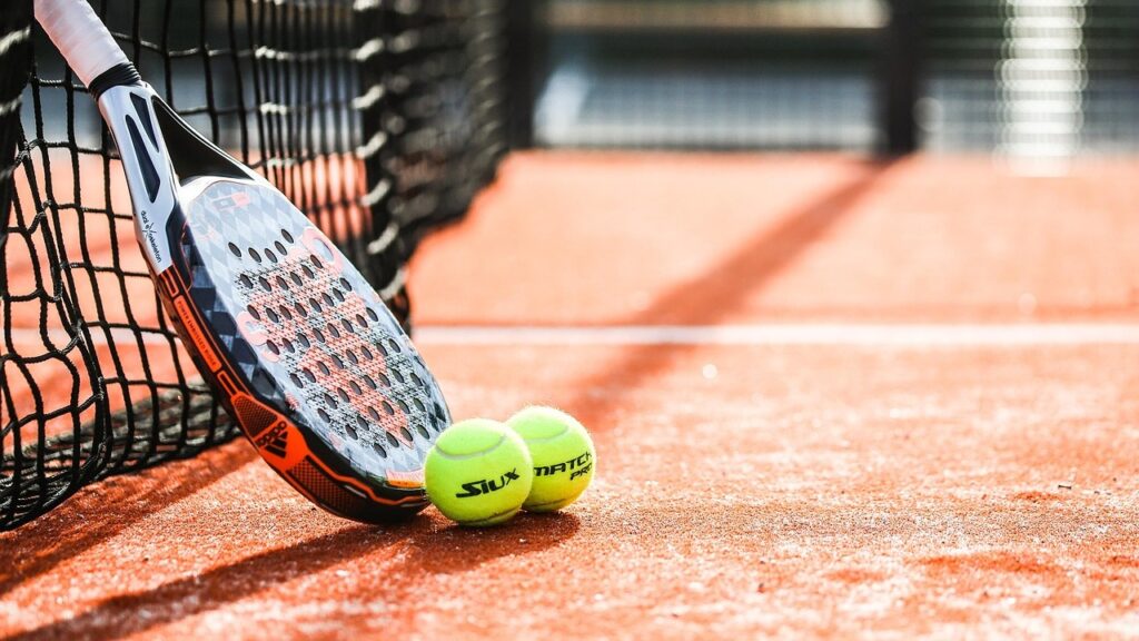 Padelracket en ballen op de baan, symbool voor miscommunicatie tijdens padelwedstrijden
