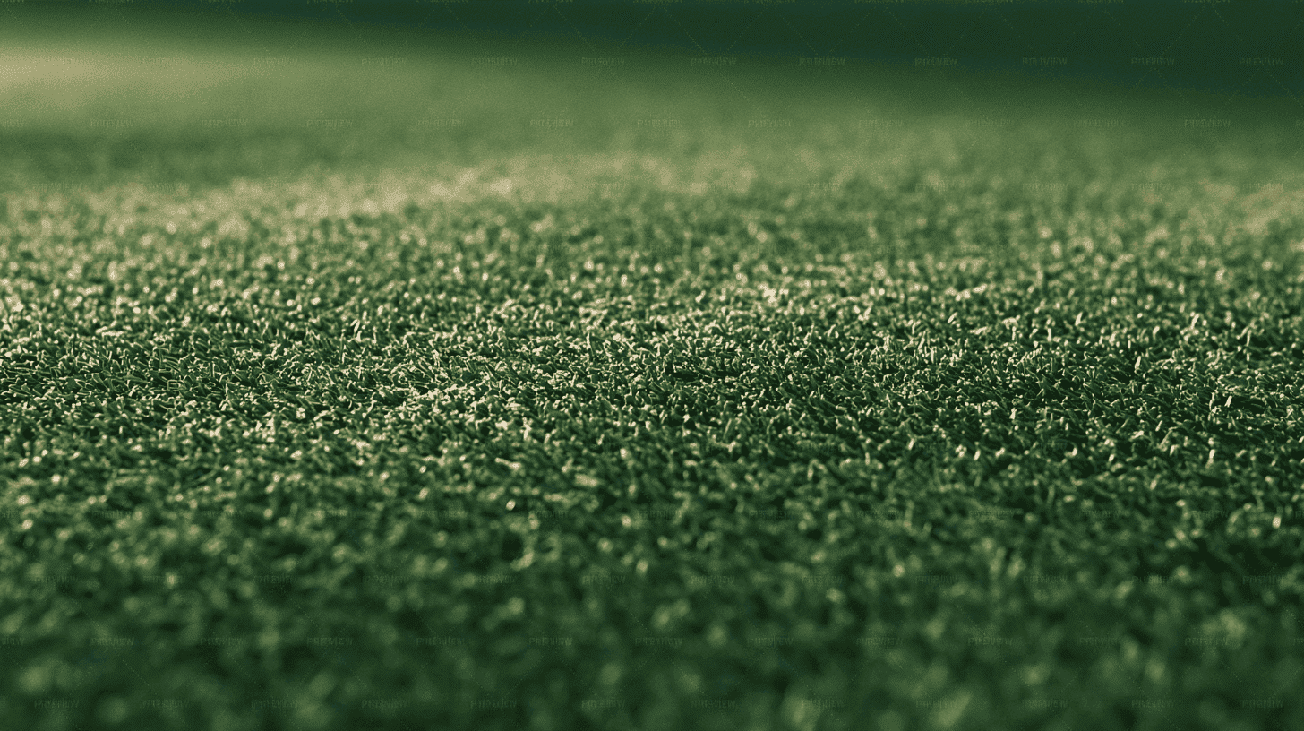 Close-up van kunstgras met zandinstrooiing op een padelbaan in de zon